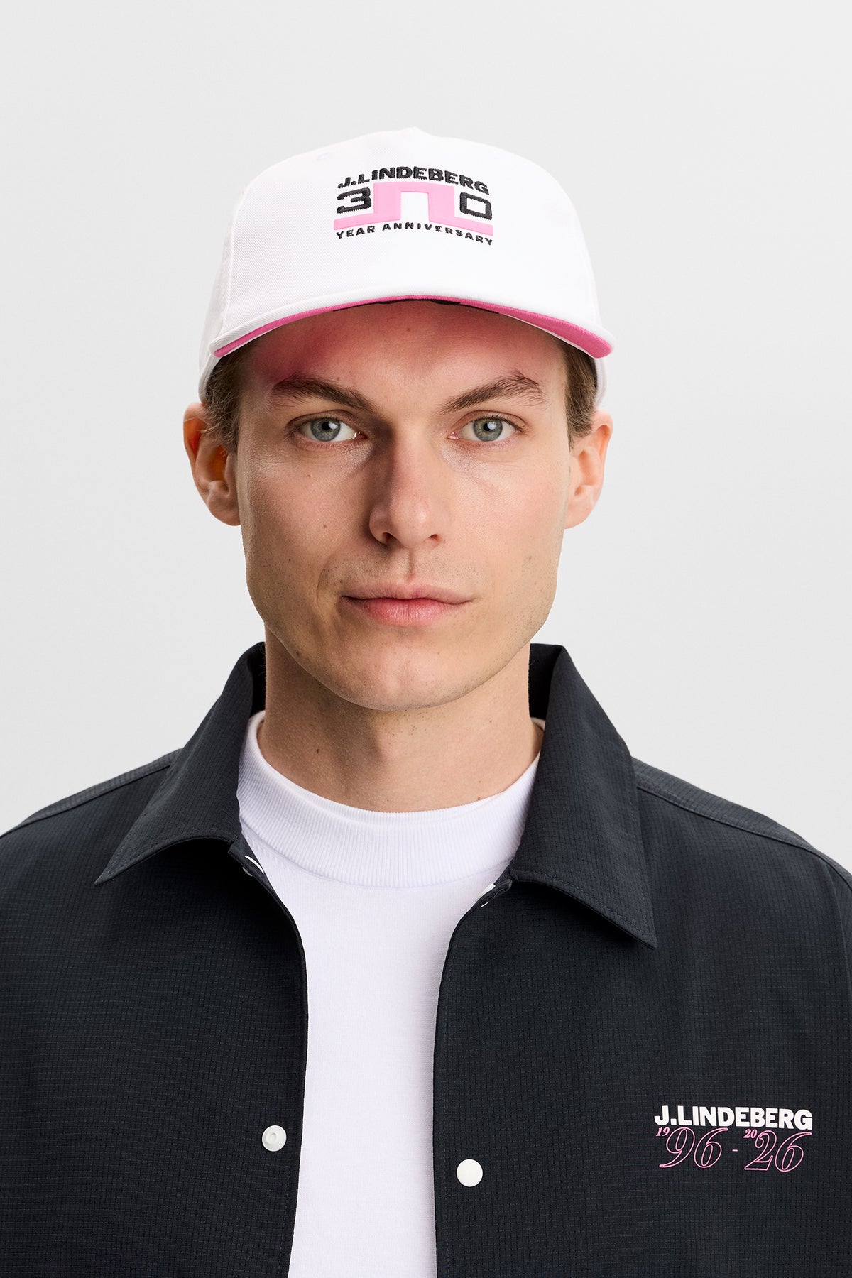 J.Lindeberg 30Y Anniversary Cap Vit – detalj på jubileumsprofilering fram och bak