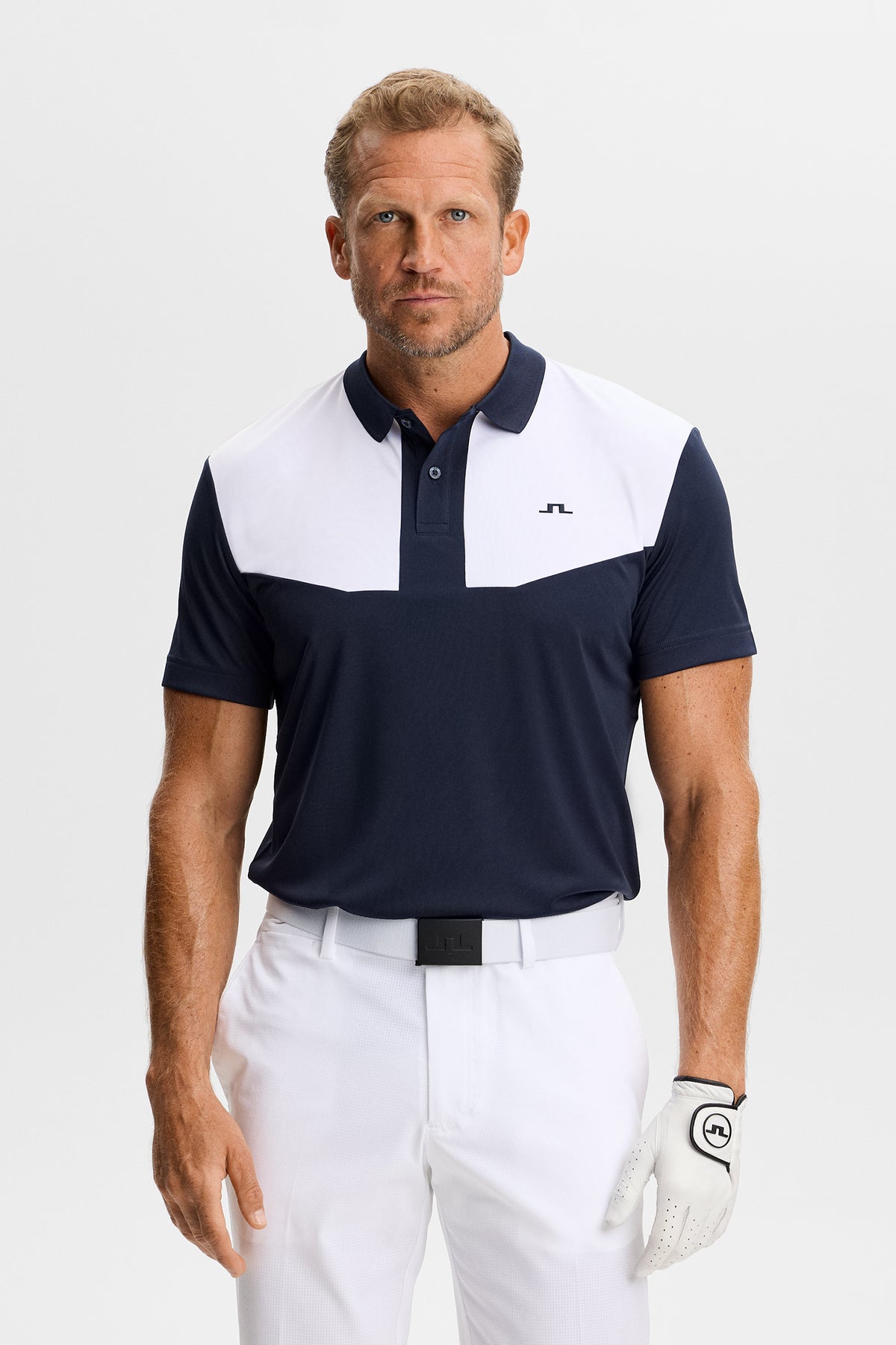 J.Lindeberg Calex Polo JL Navy – framifrån som visar kontrasterande bröstpaneler och Bridge-logotyp