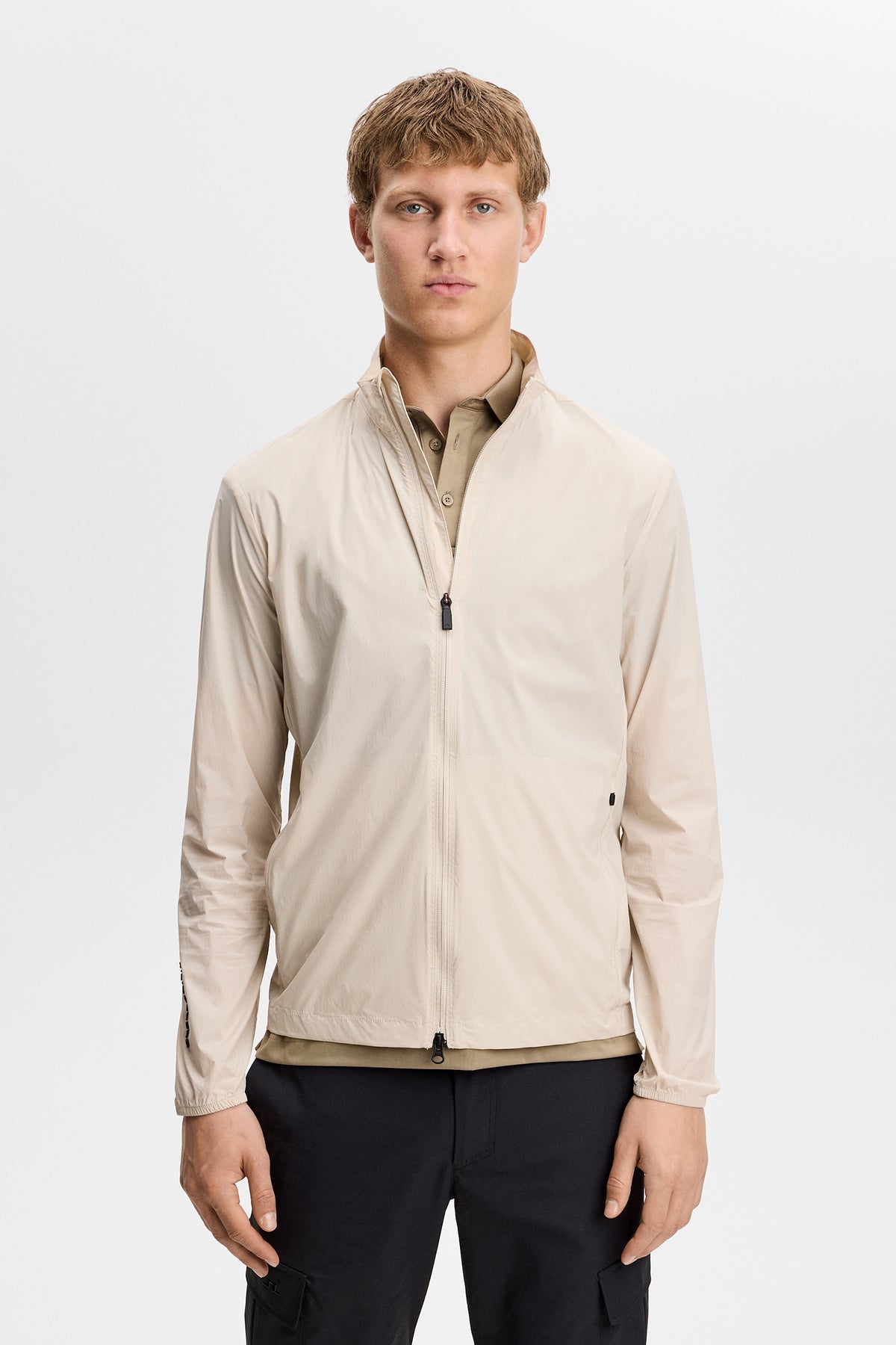 J.Lindeberg Tour Tech Packable Jacket Moonbeam – frontdetalj som visar Flex Tech 2.0-tyg och dragkedja
